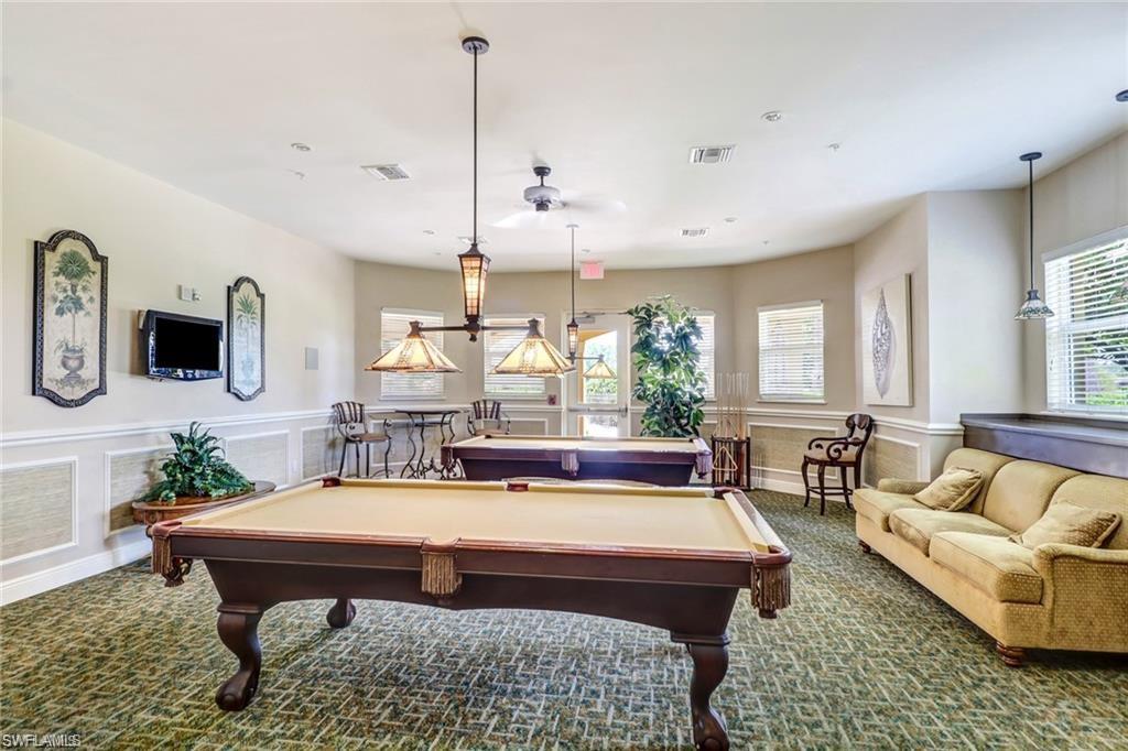 15322 Cortona Way Naples, FL 34120 - Photo 24 of 26 a living room with furniture a large window and a chandelier