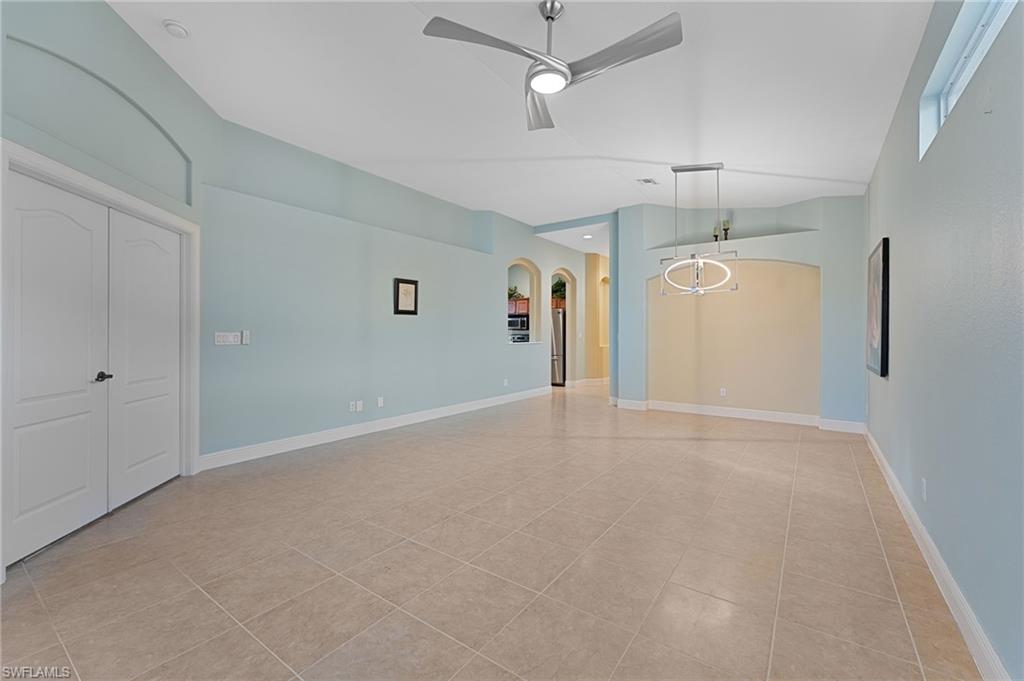 15322 Cortona Way Naples, FL 34120 - Photo 3 of 26 en empty room with ceiling fan and window