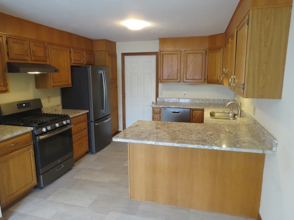 5 B Pond View Way, Unit 5B Northborough, MA 01532 - Photo 3 of 16 a kitchen with stainless steel appliances granite countertop a sink a stove and a refrigerator
