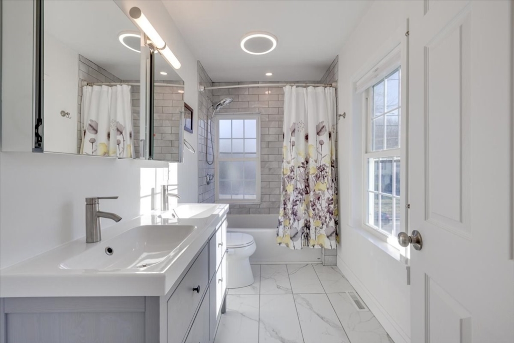 1 Bennett Street Natick, MA 01760 - Photo 21 of 28 a bathroom with a sink a toilet and shower