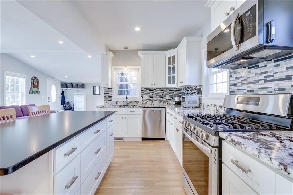 1 Bennett Street Natick, MA 01760 - Photo 7 of 28 a kitchen with stainless steel appliances granite countertop a stove a sink and a microwave