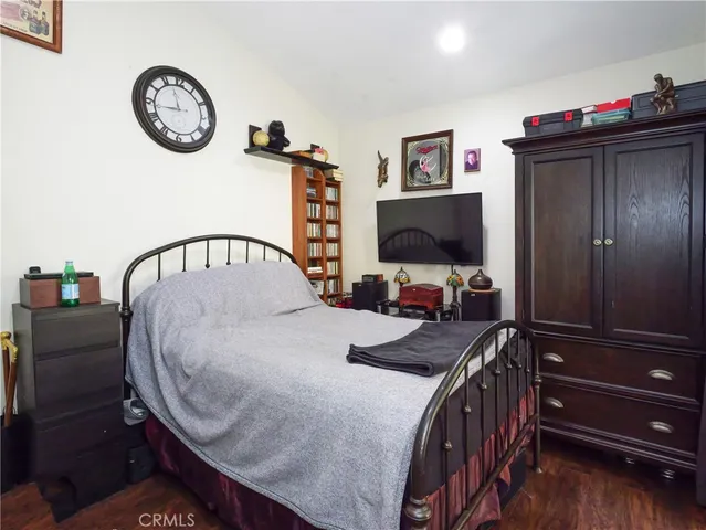 a bedroom with a bed and a flat tv screen on the dresser
