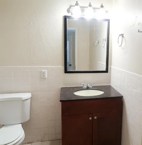 a bathroom with a toilet sink and mirror