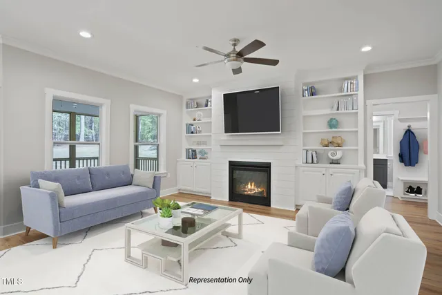 a living room with stainless steel appliances furniture and a kitchen view