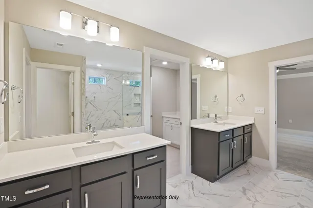 a bathroom with a granite countertop sink a large mirror and shower