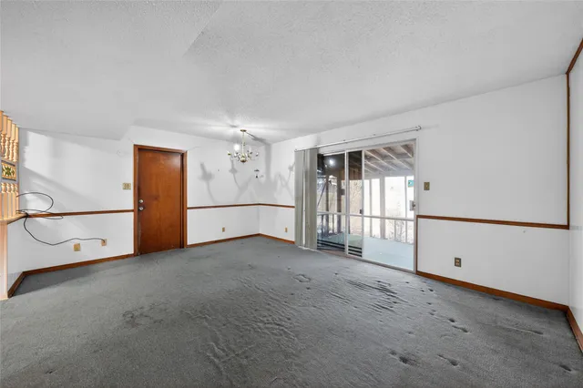 an empty room with a cabinet and a refrigerator