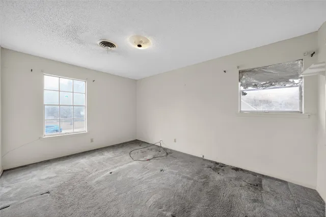 an empty room with windows and closet