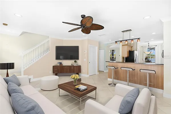 a living room with furniture a flat screen tv and kitchen view