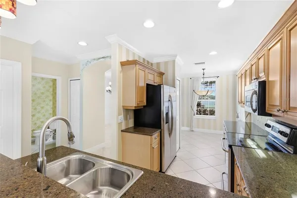 a kitchen with stainless steel appliances kitchen island a refrigerator sink and cabinets