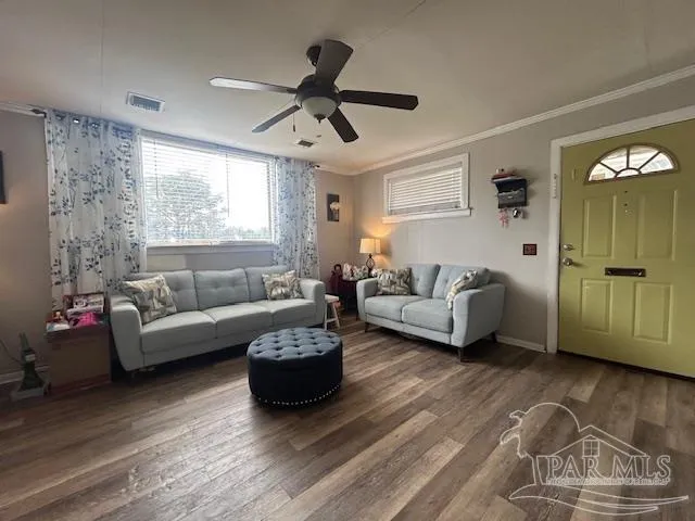 a living room with furniture wooden floor and a window