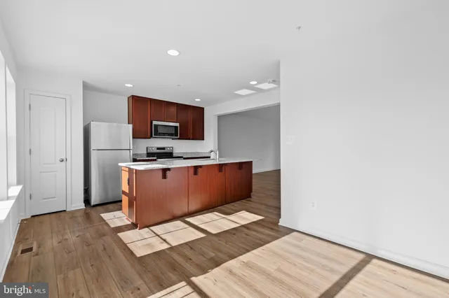 a kitchen with stainless steel appliances wooden cabinets a refrigerator and a stove