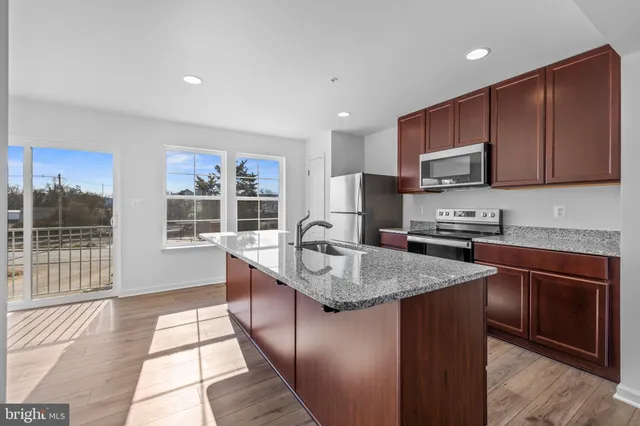 a kitchen with stainless steel appliances granite countertop a stove a sink a microwave and a refrigerator