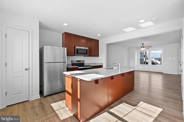 a kitchen with stainless steel appliances granite countertop a refrigerator a stove a sink and a refrigerator