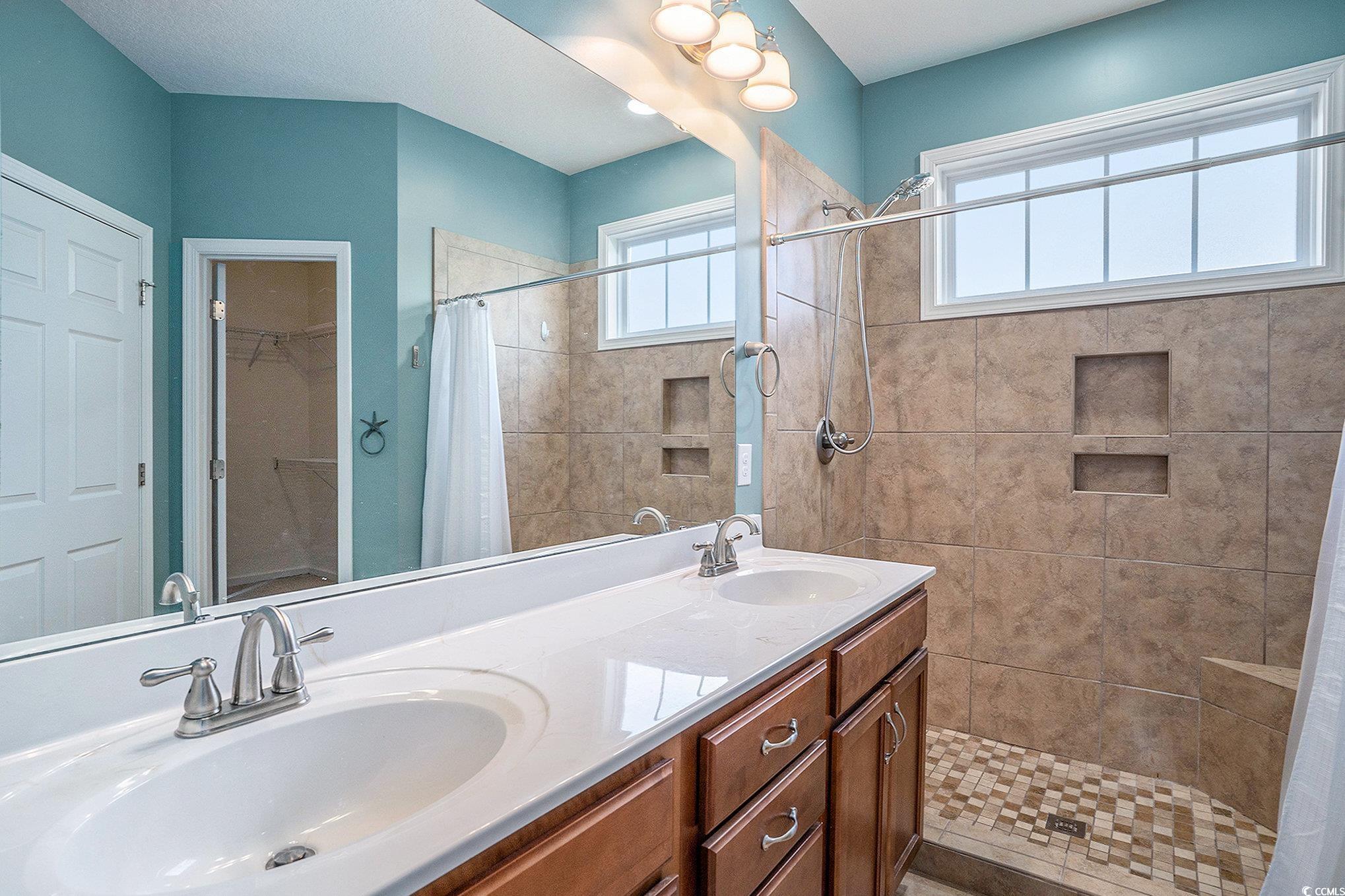 1018 Red Sky Lane, Unit 101 Murrells Inlet, SC 29576 - Photo 22 of 35 Bathroom featuring a shower stall, double vanity, and a walk in closet
