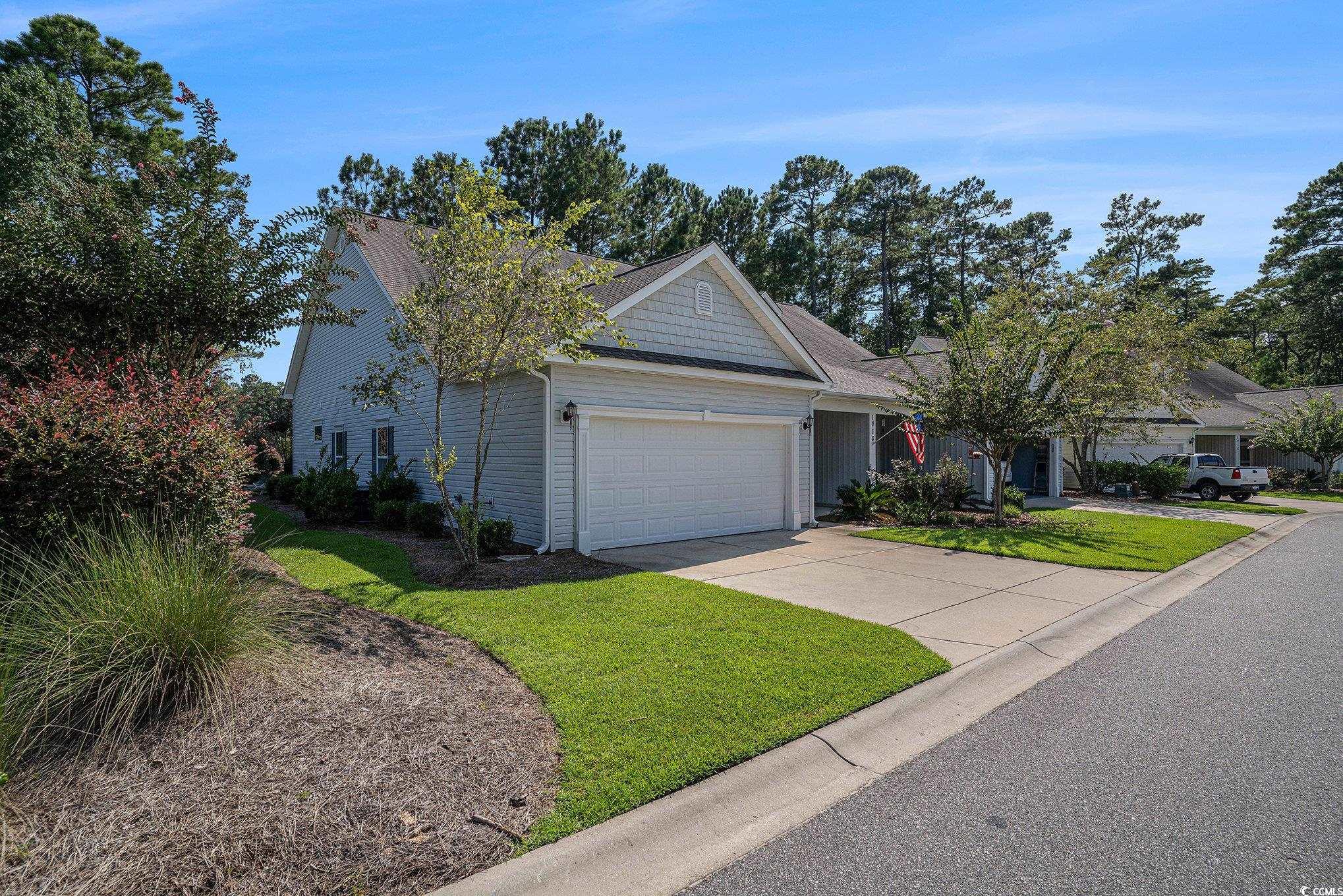 1018 Red Sky Lane, Unit 101 Murrells Inlet, SC 29576 - Photo 6 of 35 View of front of home featuring a garage, a front yard, concrete driveway, and a shingled roof