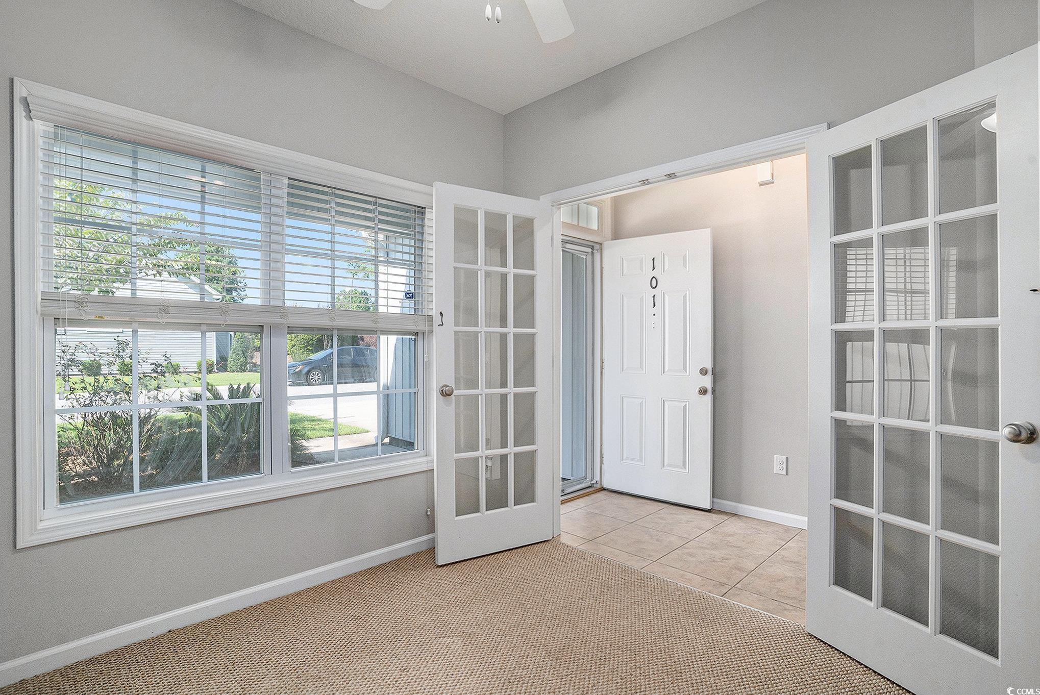 1018 Red Sky Lane, Unit 101 Murrells Inlet, SC 29576 - Photo 10 of 35 Empty room with french doors, light colored carpet, light tile patterned floors, and ceiling fan