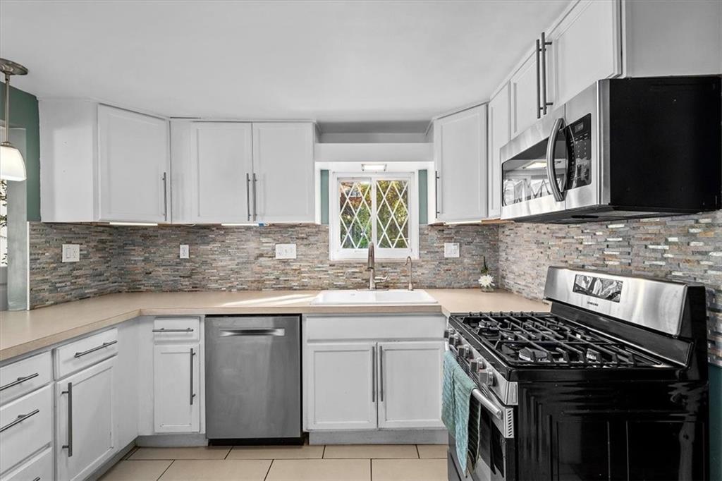 4340 Stanton Avenue Pittsburgh, PA 15201 - Photo 11 of 25 a kitchen with granite countertop cabinets stainless steel appliances and a sink