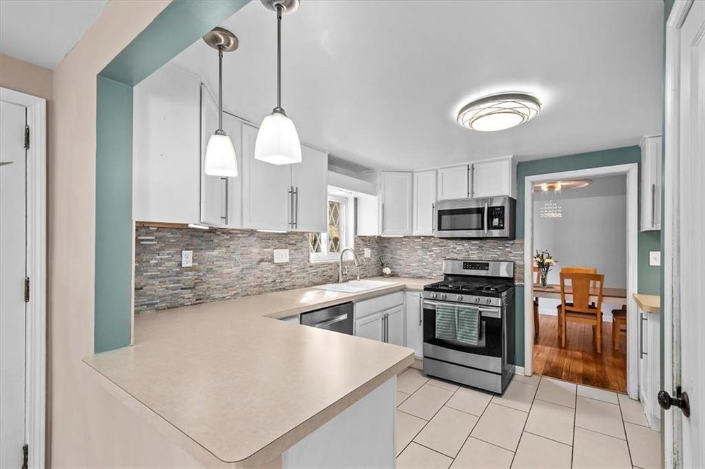 4340 Stanton Avenue Pittsburgh, PA 15201 - Photo 12 of 25 a kitchen with stainless steel appliances granite countertop a stove a sink and a refrigerator