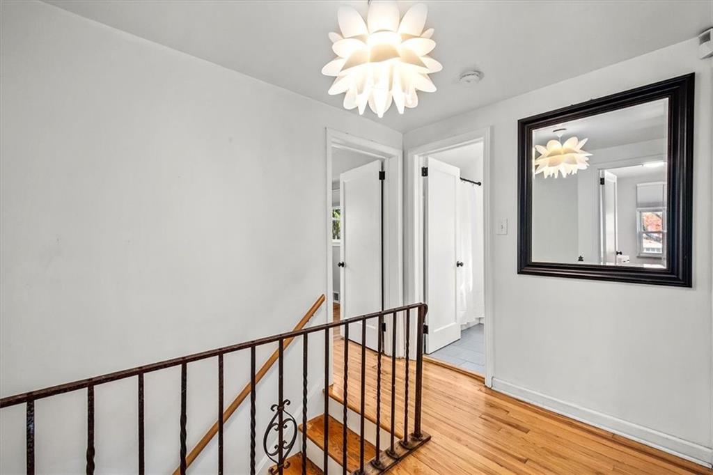 4340 Stanton Avenue Pittsburgh, PA 15201 - Photo 18 of 25 a view of a hallway with wooden floor and chandelier