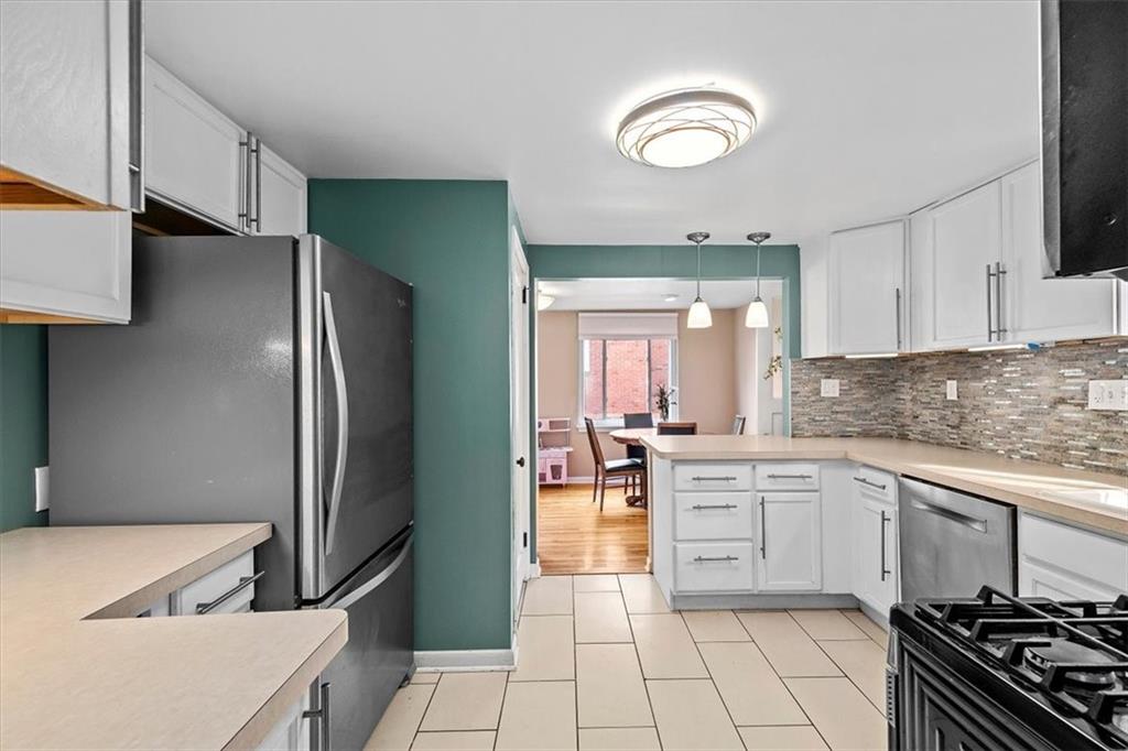 4340 Stanton Avenue Pittsburgh, PA 15201 - Photo 10 of 25 a kitchen with stainless steel appliances granite countertop a refrigerator and a stove top oven