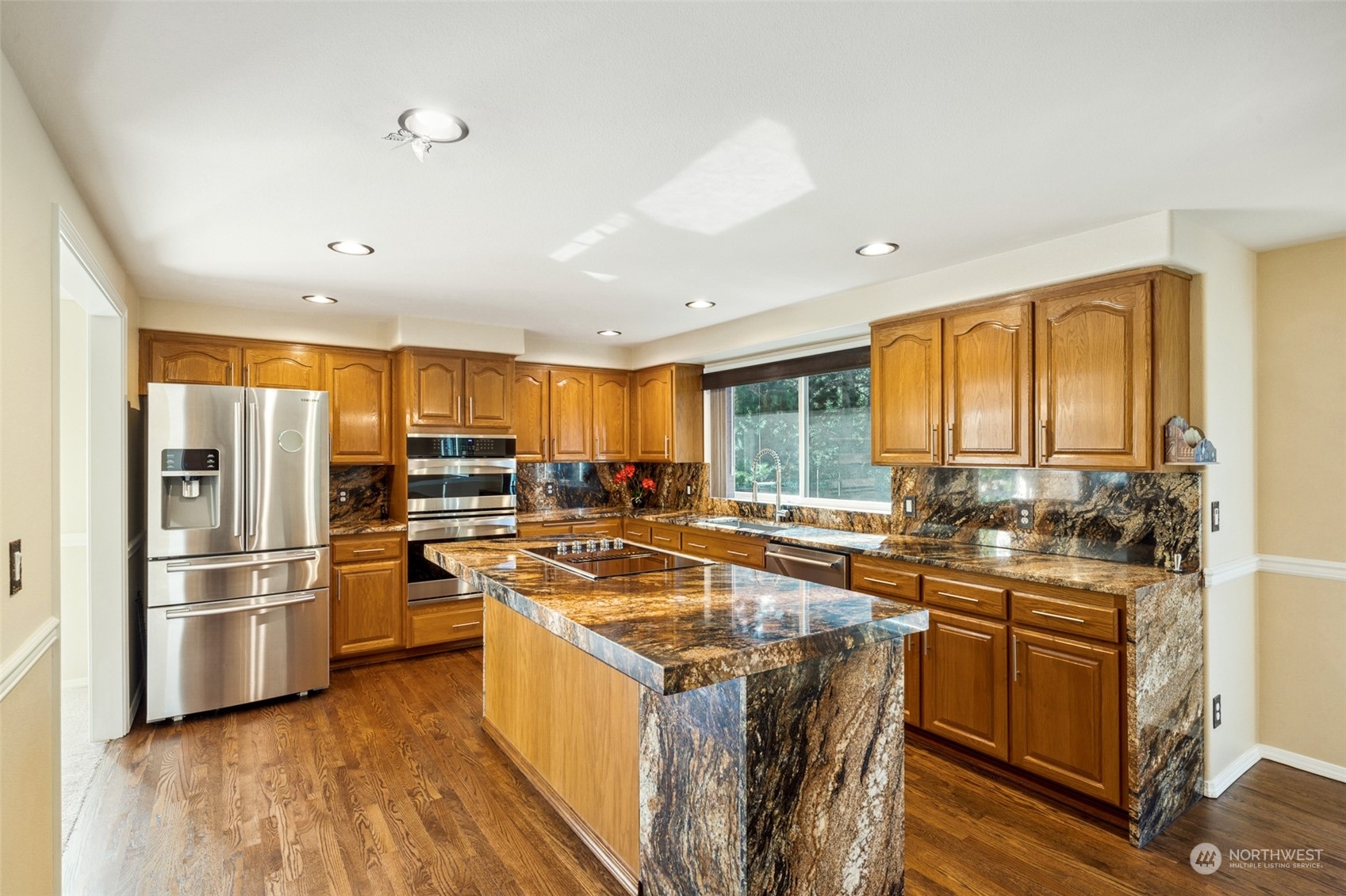 4609 Southwest 328th Place Federal Way, WA 98023 - Photo 9 of 32 a kitchen with stainless steel appliances granite countertop a stove top oven a refrigerator a sink and dishwasher with wooden floor