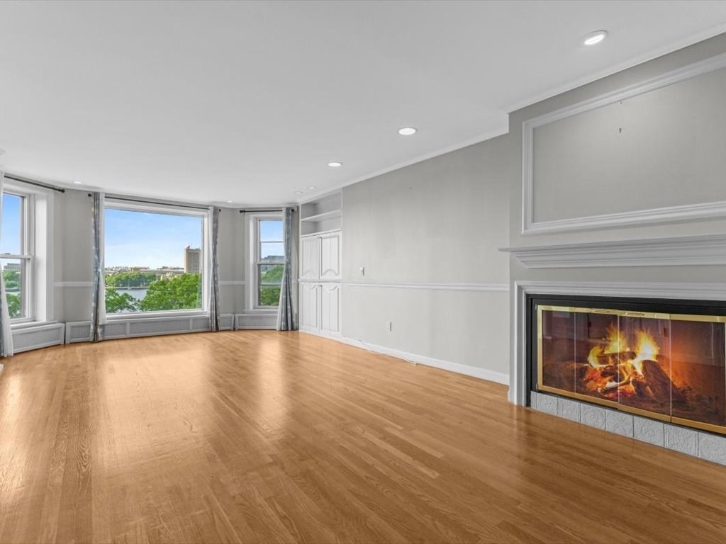 458 Beacon Street, Unit 6 Boston, MA 02115 - Photo 2 of 16 a view of an empty room with wooden floor fireplace and a window