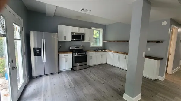 a kitchen with stainless steel appliances a refrigerator sink and microwave