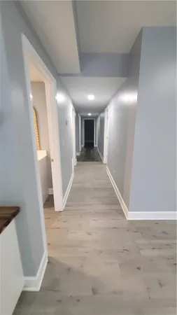 a view of a hallway with wooden floor and a living room
