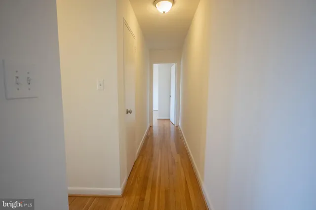a view of a hallway with wooden floor
