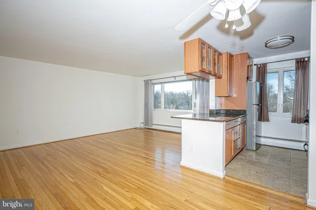 a kitchen with a wooden floor and large windows