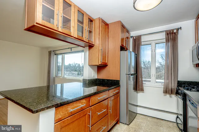 a kitchen with granite countertop a sink and a refrigerator
