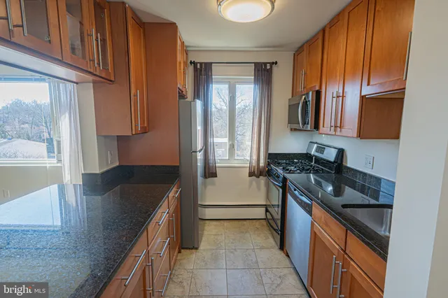 a kitchen with granite countertop a sink stove and refrigerator