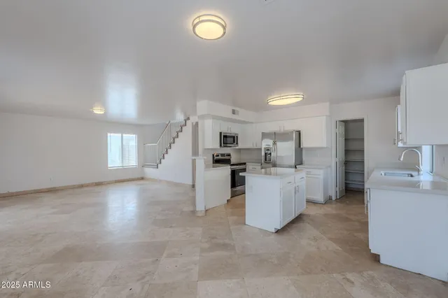 a view of a kitchen with cabinets and stainless steel appliances