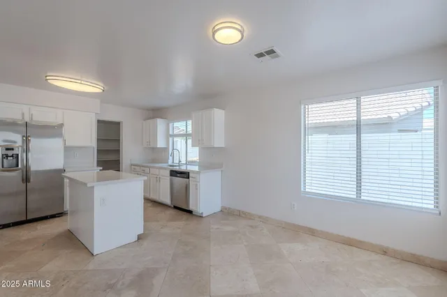 a kitchen with a refrigerator sink and cabinets