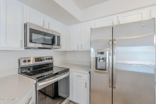 a kitchen with stainless steel appliances granite countertop a sink and a stove