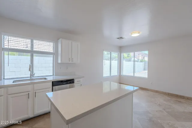a kitchen with white cabinets and a window