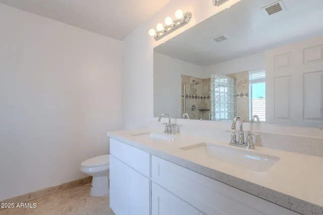 an empty room with wooden floor and a ceiling fan