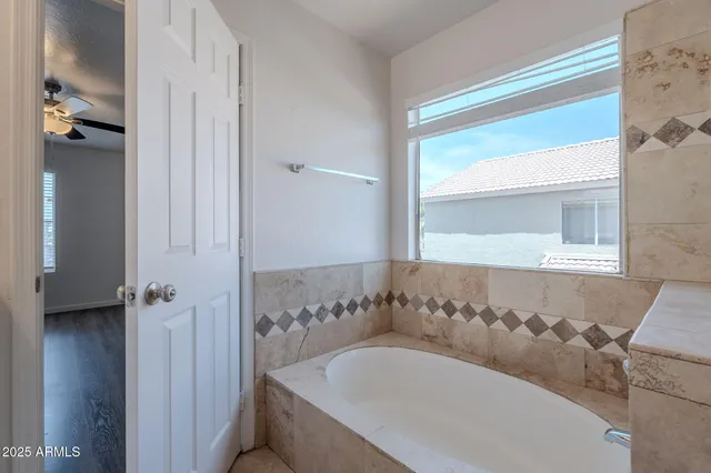 a view of an empty room and chandelier fan