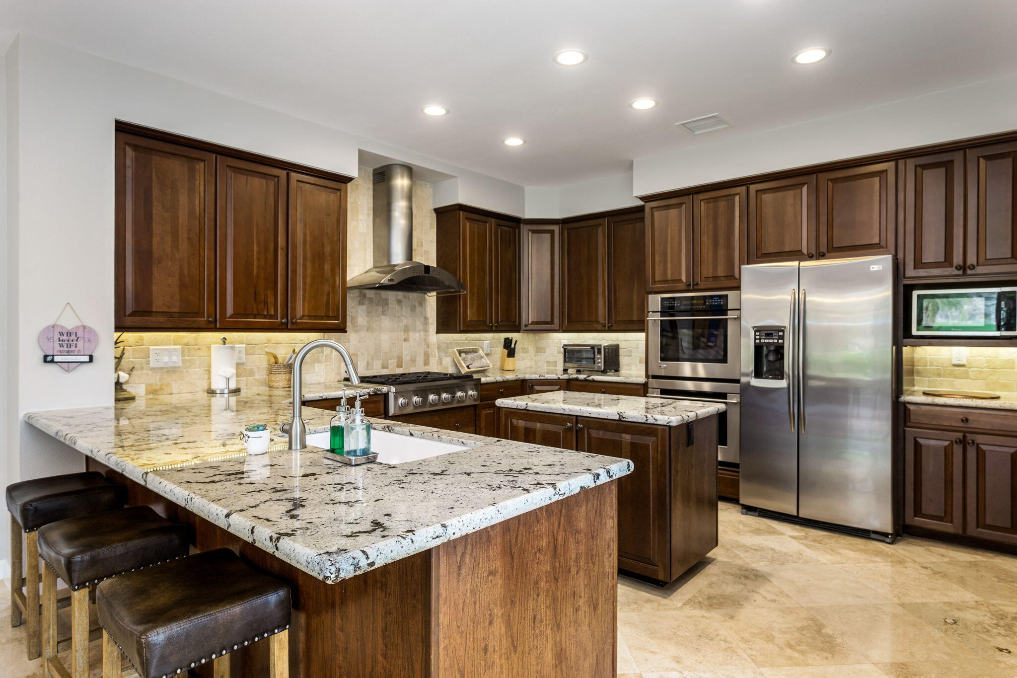 55685 Riviera La Quinta, CA 92253 - Photo 20 of 75 a kitchen with kitchen island granite countertop a sink stove and refrigerator