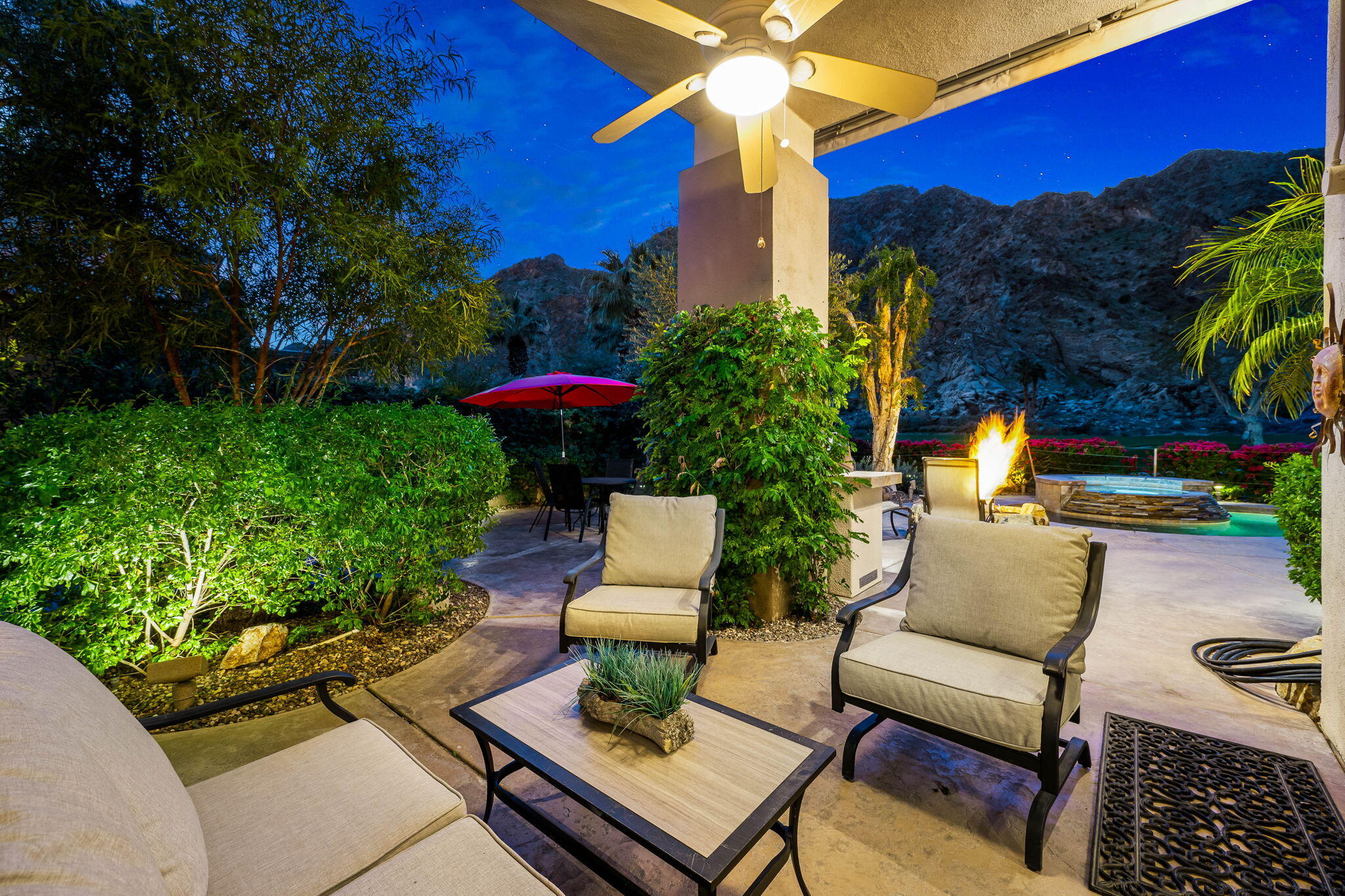 55685 Riviera La Quinta, CA 92253 - Photo 54 of 75 a view of a patio with couches table and chairs under an umbrella with potted plants