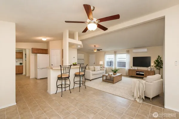 a living room with furniture kitchen view and a large window