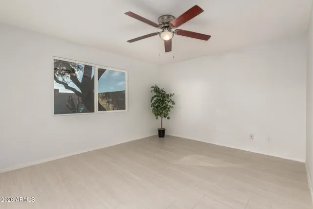 an empty room with a window and a ceiling fan