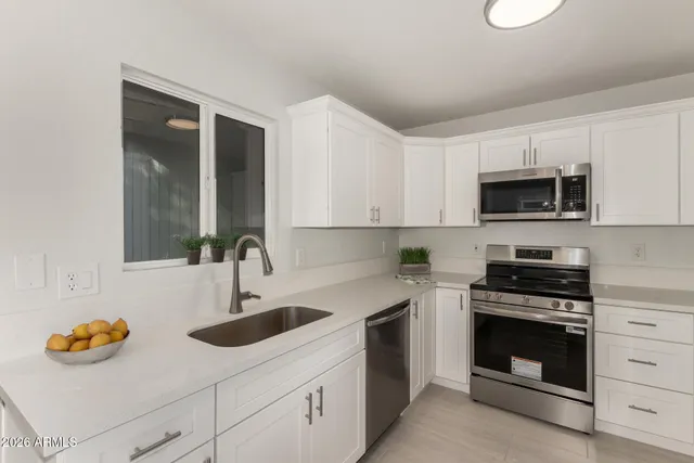 a kitchen with stainless steel appliances a stove a sink and a microwave