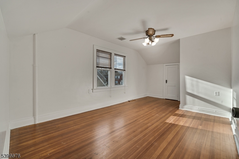 983 Colonial Avenue Union, NJ 07083 - Photo 9 of 28 an empty room with wooden floor ceiling fan and windows