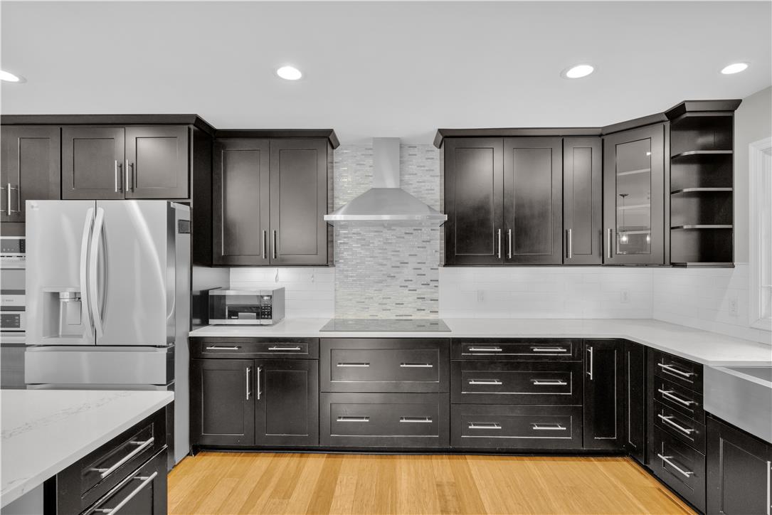 3396 Darien Road Bethlehem, PA 18020 - Photo 14 of 44 A contemporary kitchen features dark cabinetry, bright counters, and shining stainless-steel appliances for a sleek look.