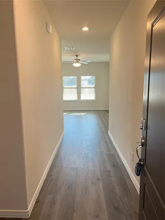 a view of a hallway with wooden floor