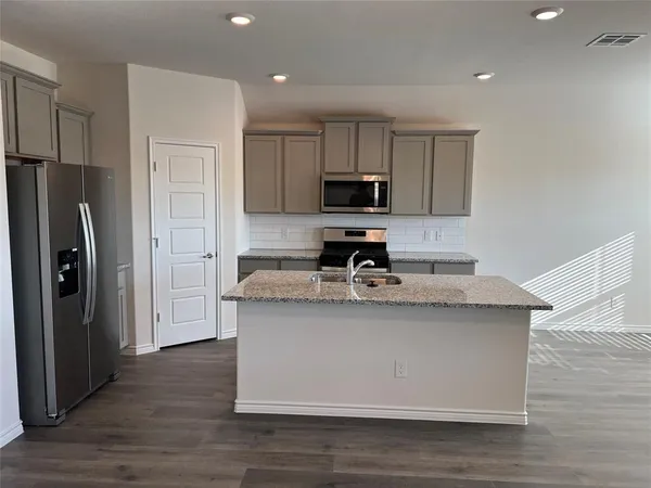 a kitchen with stainless steel appliances granite countertop a sink stove and refrigerator