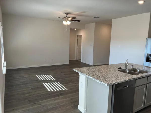 a kitchen with a sink a refrigerator and chandelier