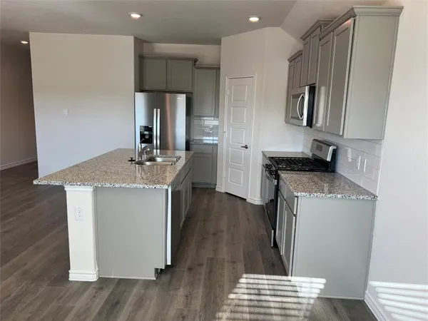 a kitchen with sink refrigerator and microwave