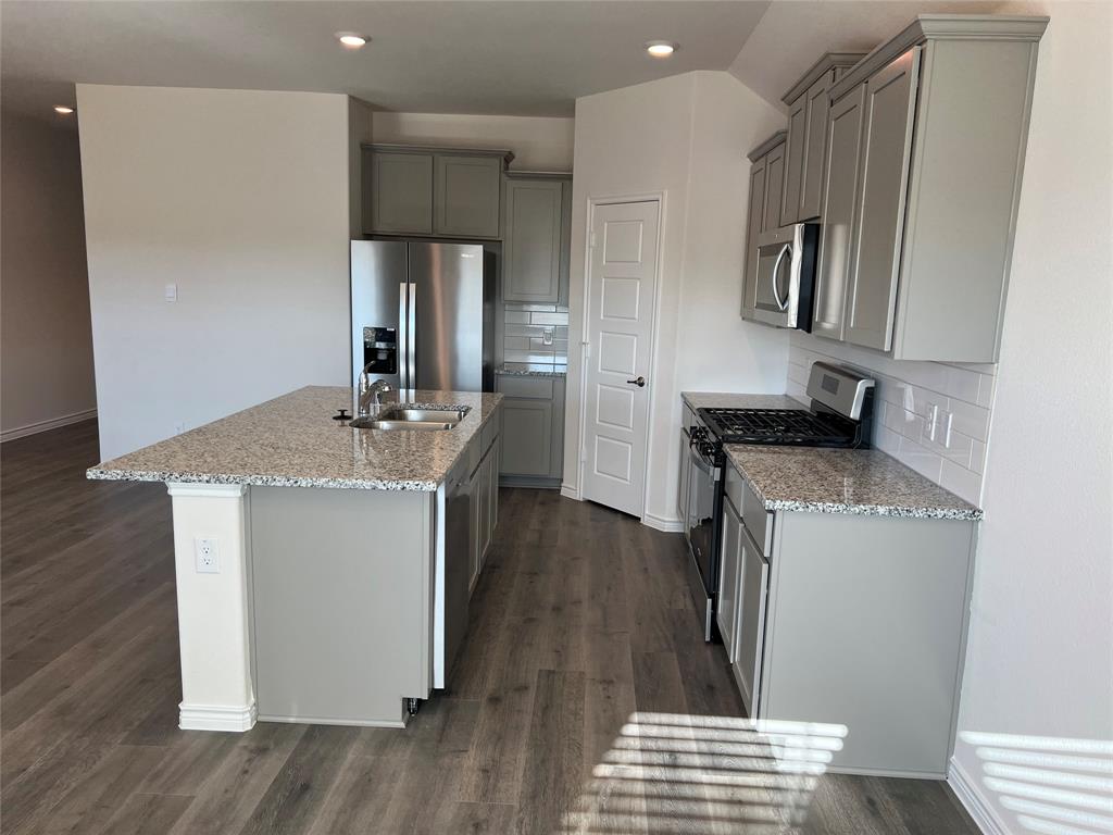 807 Cinnabar Way Princeton, TX 75407 - Photo 7 of 22 a kitchen with sink refrigerator and microwave